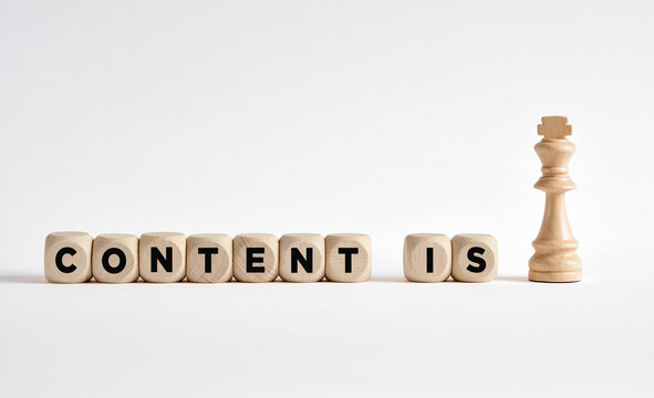 The word content is king written on wooden blocks with a king chess piece