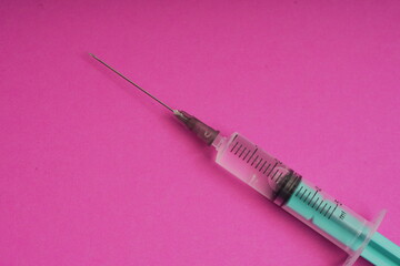 Medical syringe on a pink background. A syringe for injection. The concept of health and beauty