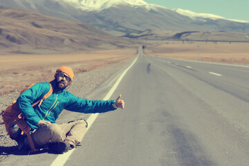 hiker with backpack on the highway hitchhiking, travel activity trip