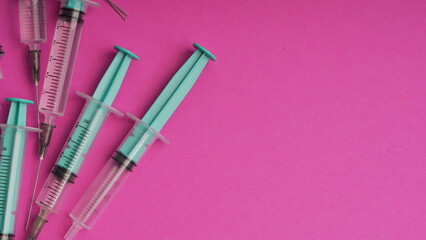 medical disposable syringe for injection in the hospital. plastic syringe on a pink background. the concept of fighting viruses and diseases