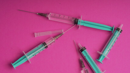 medical disposable syringe for injection in the hospital. medical devices on a pink background