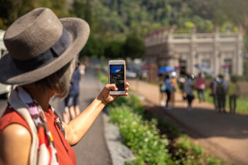 Tourist woman taking photo on her mobilephone on beautiful landscape.