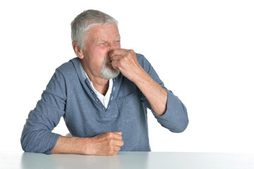 Portrait of senior man sitting at table on white background