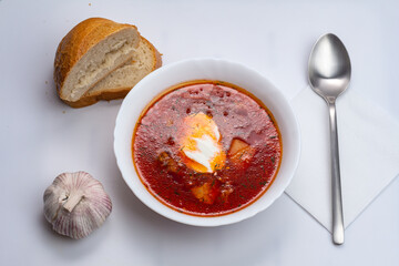 National food on white background. Russian borscht with sour cream, garlic, pepper. Food and health