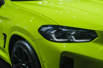 headlight in luxury green car background with showroom copy space. Modern and expensive sport car...