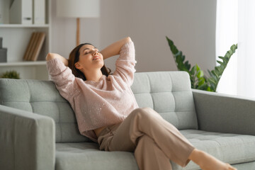 woman resting on a sofa - obrazy, fototapety, plakaty