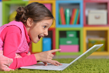 Portrait of emotional cute girl using laptop