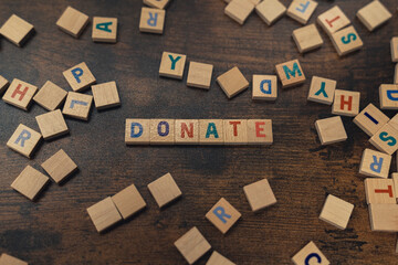 DONATE - a word put together with alphabet letters on the brown wooden table charity concept. High quality photo