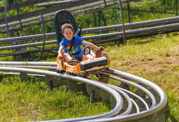 Jugendlicher hat Spaß bei einer rasanten Fahrt mit dem Alpine Coaster