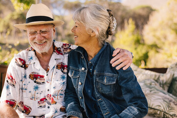 Happy senior couple smiling cheerfully at a spa resort - obrazy, fototapety, plakaty