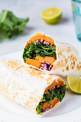 Vegan burrito wrap with sweet potato, kale and onion. Vegetarian food concept.