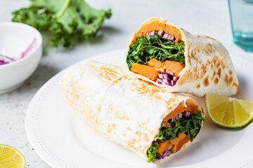 Vegan burrito wrap with sweet potato, kale and onion. Vegetarian food concept.