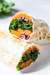 Vegan burrito wrap with sweet potato, kale and onion. Vegetarian food concept.