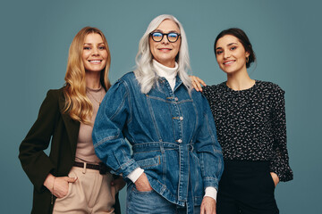 Happy trio of women standing together in a studio