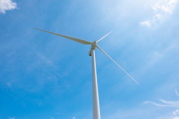 View of a wind farm, with tall wind turbines for electricity generation with copy space. Green energy concept.