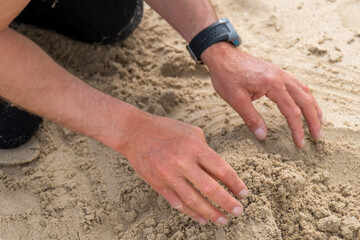 mains dans le sable