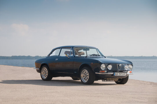 BARI, ITALY-JULY 4,2021: Italian classic car Alfa Romeo Giulia GT 1300 Junior parked on the road against the background of the sea. Automotive photography. Space for text. Background with retro car.