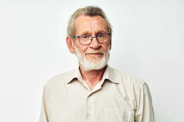 Photo of retired old man with a gray beard in a shirt and glasses light background