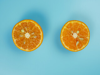 Creative concept made from oranges on blue pastel background. healthy and minimal fruit concept