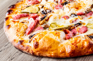 Pizza with Mozzarella cheese, salami, chicken meat, beef, ham, Tomato sauce, pepper, spices. Italian pizza on wooden background