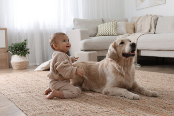 Cute little baby with adorable dog on floor at home