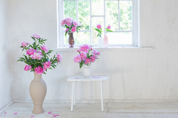 pink peony in vase on grunge white interior