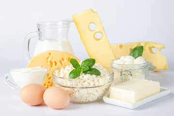 Dairy products, Milk, Sour Cream, Assorted Cheese, Cottage Cheese, Butter and Eggs on white background