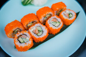 a roll with salmon and rice with tobiko caviar