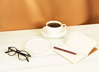 Obraz na płótnie Canvas coffee cup and notebook on a white background