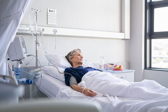 Lonely old woman lying on hospital bed