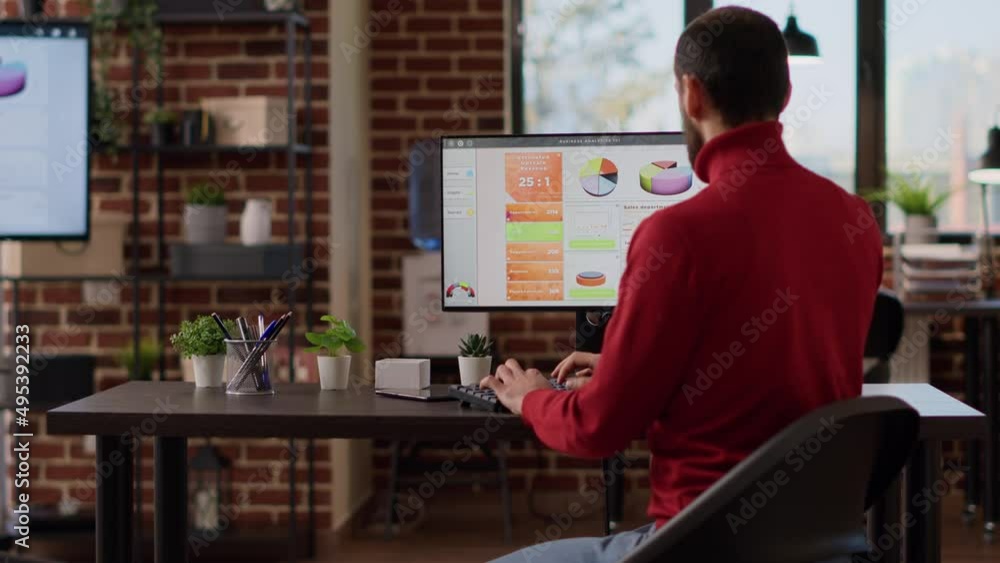 Poster sales consultant using e commerce statistics on computer monitor to develop financial growth and bus