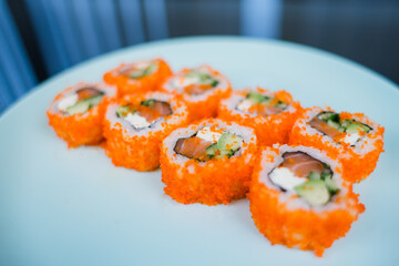 a roll with salmon and rice with tobiko caviar