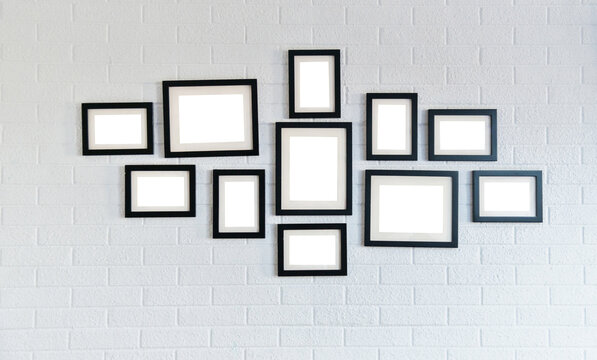 Group of wooden picture frames on white brick wall
