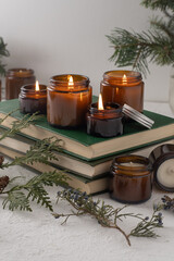 A set of different aroma candles in brown glass jars. Scented handmade candle. Soy candles are burning in a jar. Aromatherapy and relax in spa and home. Still life. Fire in brown jar
