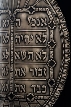 A pewter breastplate inscribed with the 10 commandments covers a Sefer Torah or Jewish scroll of the five books of Moses.