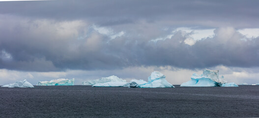 Cloudscape over icebergs floating in the sea off the coast of Disko Island, Greenland 
