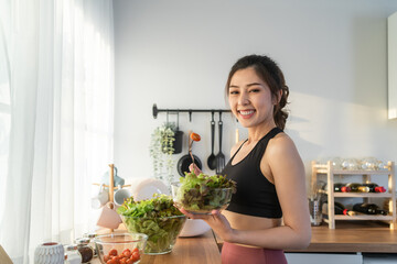 Portrait of Asian attractive woman hold salad bowl and look at camera.