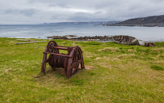 Landscape with old rowboats, fishing equipment, coastline and mountains at the abandoned village of Hamningberg, Varanger peninsula, Finnmark, Norway