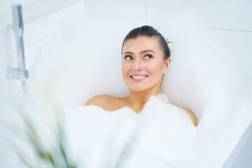 Young nice brunette woman having bath in bathtub