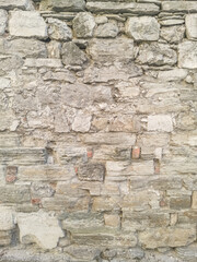 Medieval stone wall of limestone, textured.