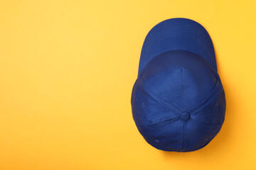Stylish blue baseball cap on yellow background, top view. Space for text © New Africa