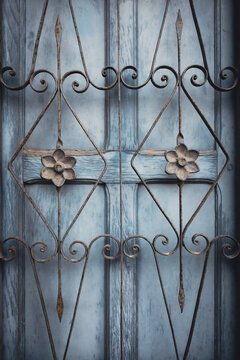 Ventana de madera antigua con reja de metal oxidado