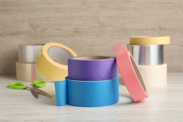 Many different rolls of adhesive tape on wooden table