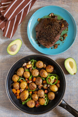 Large fried piece of ham meat in a pan with vegetables and spices, American lunch fried piece of meat and potatoes, beans in sauce and snacks, copy space for text