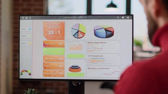 Office worker analyzing business charts and graphs on monitor display, planning marketing strategy with financial report data. Young man working on computer with diagram. Close up.