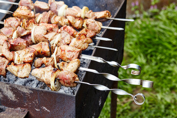 Marinated shashlik preparing on a barbecue grill over charcoal. Traditional Russian shashlik on a barbecue skewer