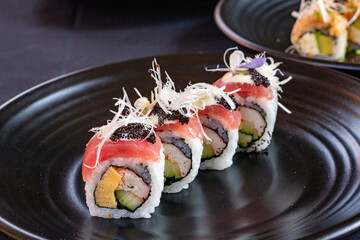 Tuna roll on black plate.