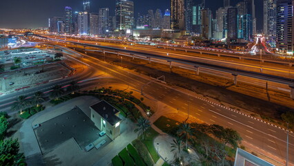Dubai Marina skyscrapers and Sheikh Zayed road with metro railway aerial night timelapse, United...