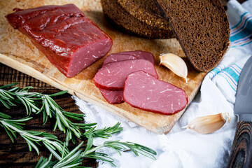 pork balyk on a dark background sliced on a dark background, concept for a farm shop 