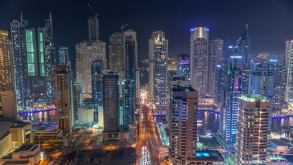 Naklejka premium Dubai Marina skyscrapers and Sheikh Zayed road with metro railway aerial night timelapse, United Arab Emirates